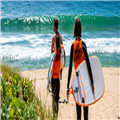 Twee surfsters lopen naar het strand in Peniche, Portugal – Clicktodo | فتاتان تحملان ألواح التزلج وتتجهان نحو شاطئ بينيش، ال